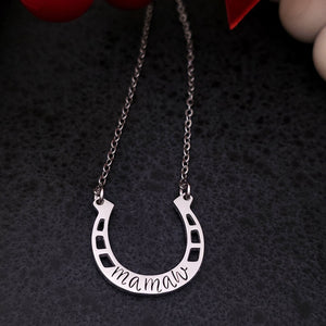 Silver necklace with a horseshoe-shaped pendant on a dark background